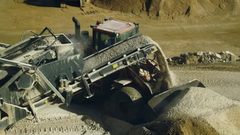 Stone crushing machine and bulldozer operator at work in quarry, slow motion Video stock 294099150
