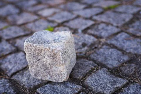 Stone cube on paving stone surface of walkway in Europe. Stock Photos