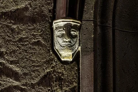 Stone decor of the gate arch in the form of the face of a warrior in armor Stock Photos