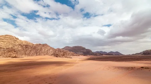 Stone desert landscape. Red rocks and sand, blue sky, white clouds Stock Footage 109074934