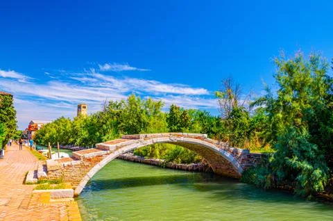 Stone Devil bridge across water canal on Torcello island Stock Photos
