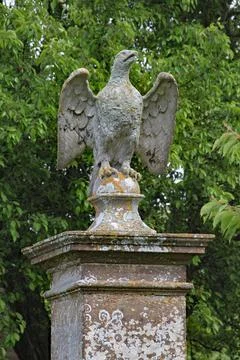 A stone eagle on a square plinth stands guard over an English country house Photos