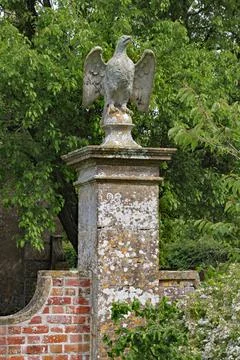 A stone eagle on a square plinth stands guard over an English country house Stock Photos