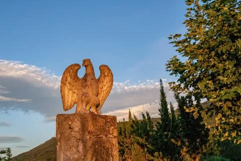 Stone eagle statue with blue sky in a countryside at the sunset. Stock Photos