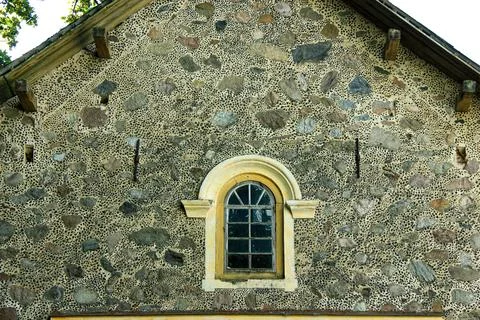 Stone facade of historic building with arched window and decorative masonry.. Fotos de archivo
