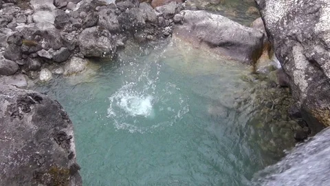 Stone falls into the water making a huge splash - slow motion with reverse Stock Footage 76770276