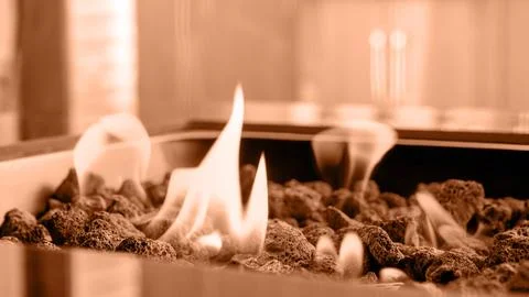 Stone firepit with fire flames. Image toned in Peach Fuzz color of the year 2024 Stock Photos