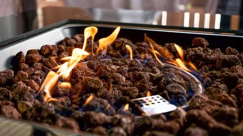 Stone firepit with fire flames. Summer camping bonfire. Stock Photos