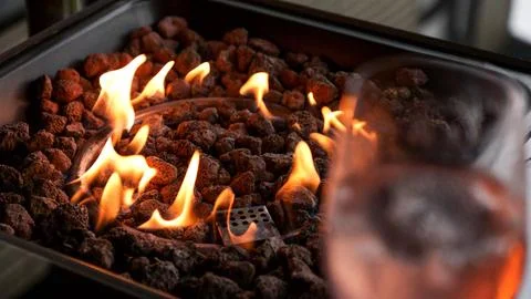Stone firepit with fire flames. Summer camping bonfire. Stock Photos