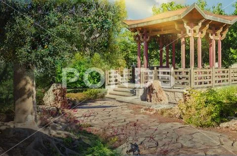 Stone footpath leading to asian wooden gazebo Stock Photos