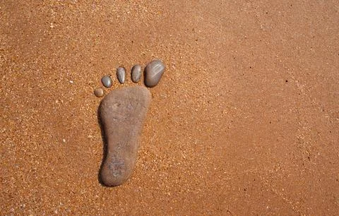 Stone Footprint on Sandy Beach, Creative Nature Concept Fotos Stock
