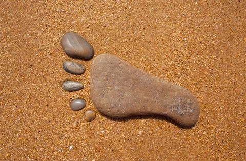 Stone Footprint on Sandy Beach 스톡 사진