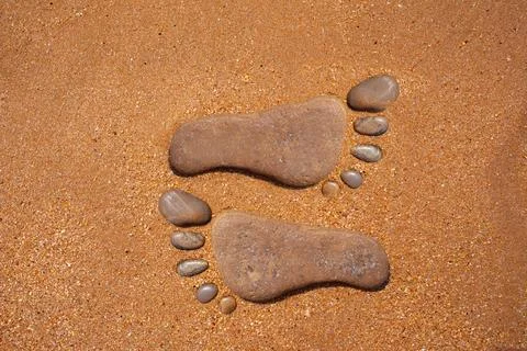 Stone Footprints on Sandy Beach 스톡 사진