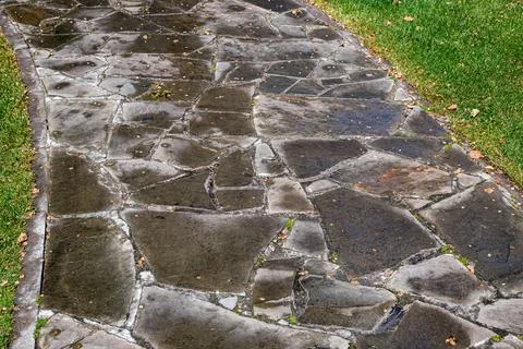 A stone garden path made of rock of different shapes. Stock Photos