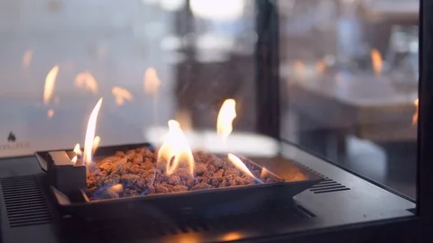 Stone gas fire pit with flames in modern fireplace in the restaurant 스톡 동영상 98481139