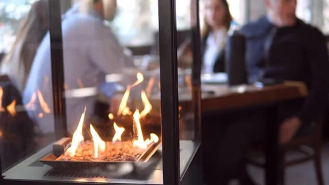 Stone gas fire pit with flames in modern fireplace in the restaurant 스톡 동영상 98481526