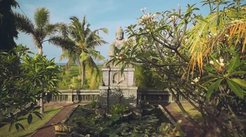 Stone hindu statue view from behind frangipani tree, slide Video stock 68082878