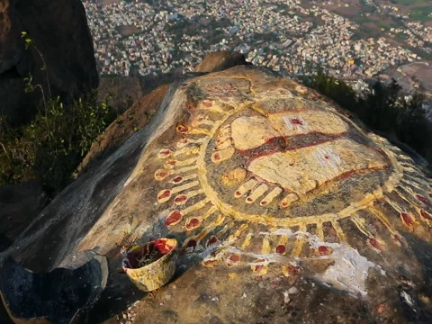 A stone with the image of the footprints of a guru on top of a mountain Aruna Stock Footage 77788875