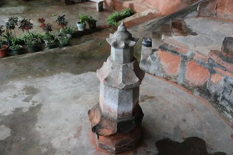 Stone lantern on a courtyard ledge with potted plants below Stock-Fotos