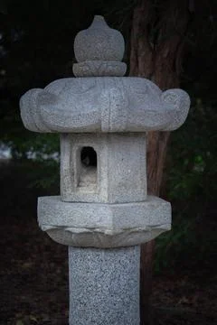 Stone lantern in a tranquil garden setting at dusk time Stock Photos