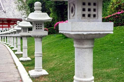 Stone lanterns line a path in Nanshan Park, surrounded by greenery. Chinese Foto stock