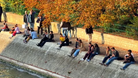 A stone ledge of the Square du Vert-Galant promenade, crowded with locals Stock-Footage 337344013