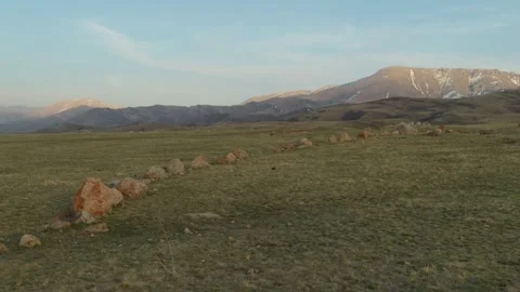 Stone line leading through steppe towards mountains at sunset Vidéo 333952949