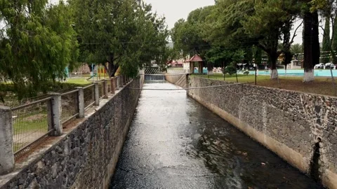 Stone Lined Canal Flowing Through Public Green Park in Tizayuca Mexico Vídeo Stock 336032329