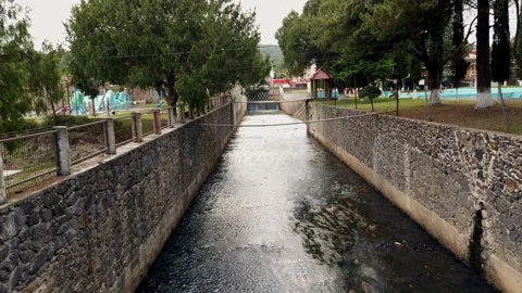 Stone Lined Water Canal Flowing Through Public Park in Tizayuca Mexico Vídeo Stock 336031907
