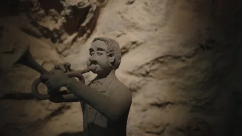 Stone man statue playing trumpet brass instrument Stock Footage 346253073