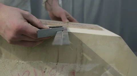 A stone mason measuring a stone plinth which is getting a plate attached Stock Footage 58641786