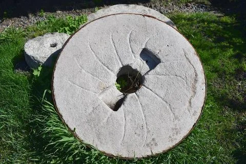 Stone millstone of an ancient mill. Stock Photos