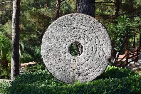 Stone millstone of an ancient mill. Stock Photos
