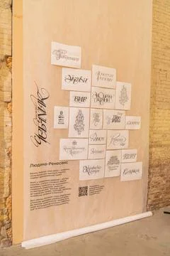 Stone or concrete wall displaying a collection of framed artwork, including.. Stock Photos
