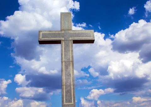 Stone Orthodox cross against a cloudy sky Stock Photos