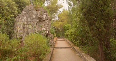 Stone Path and Rocky Outcrop Surrounded by Greenery in Castle Hill Park, Nice Stock Footage 345072466