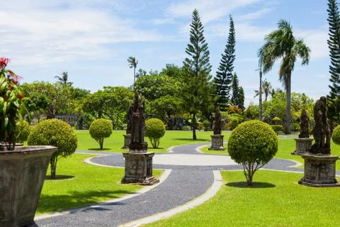 A stone path and shrubs of various shapes in the exotic Park Stock Photos