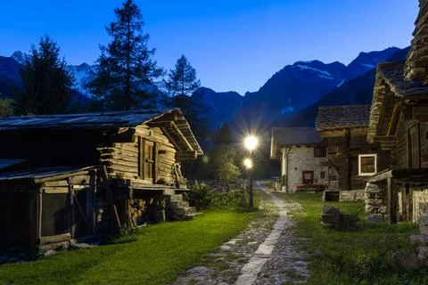 Stone path between huts and old mountain houses at dusk, Macugnaga, Italy Stock Photos