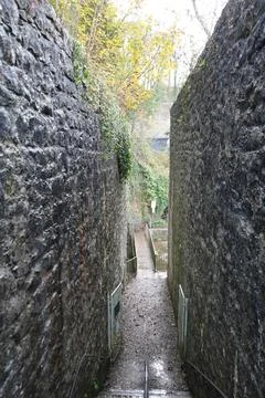 Stone Path Descending Between Ancient Walls To A Bridge In Dyserth, North Wales. Stock Photos