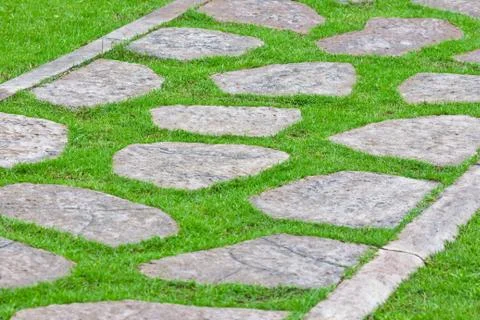 Stone path on green grass Stock Photos