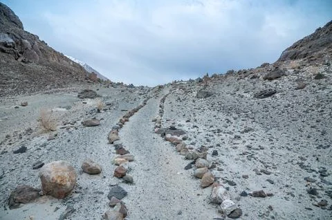 Stone path leading through the rugged Himalaya mountains, remote trekking trail  Stock Photos