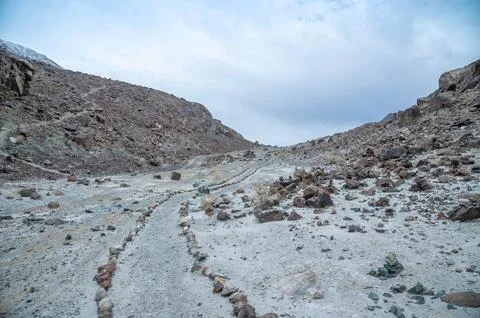 Stone path leading through the rugged Himalaya mountains, remote trekking trail  Stock Photos