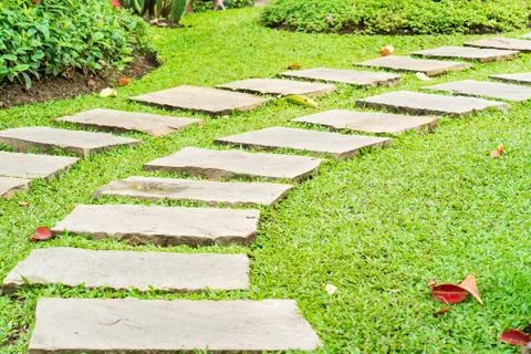 Stone path in park on green grass Stock Photos