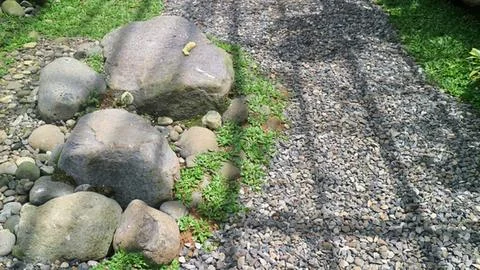 Stone pathway with grass and moss on natural ground Stock Photos