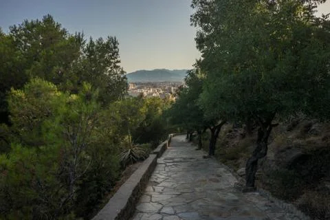 Stone pathway leading down the hill overlooking Malaga, Spain, Europe with tr Stock Photos