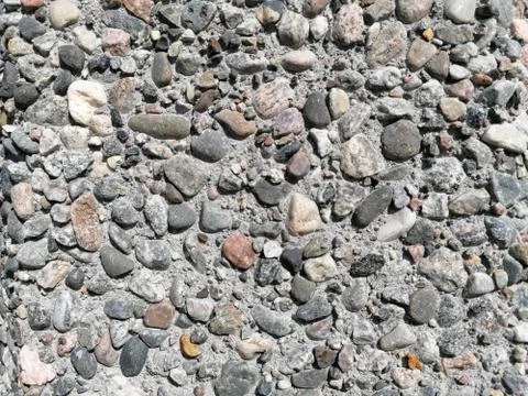 Stone pattern wall with lots of pebbles in different colors Stock Photos