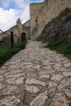 Stone paved path leading to an ancient fortress on a hill. Stock Photos