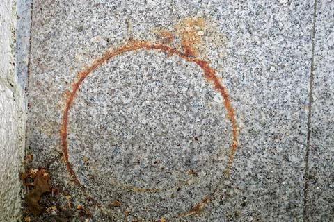 Stone paving with a rusty circular mark resembling a ring Stock Photos