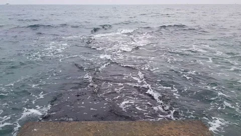 Stone pier on which the waves roll. Cloudy weather, rough sea. Stock Footage 149504484