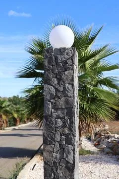 Stone pillar with a white globe light against a blue sky 스톡 사진